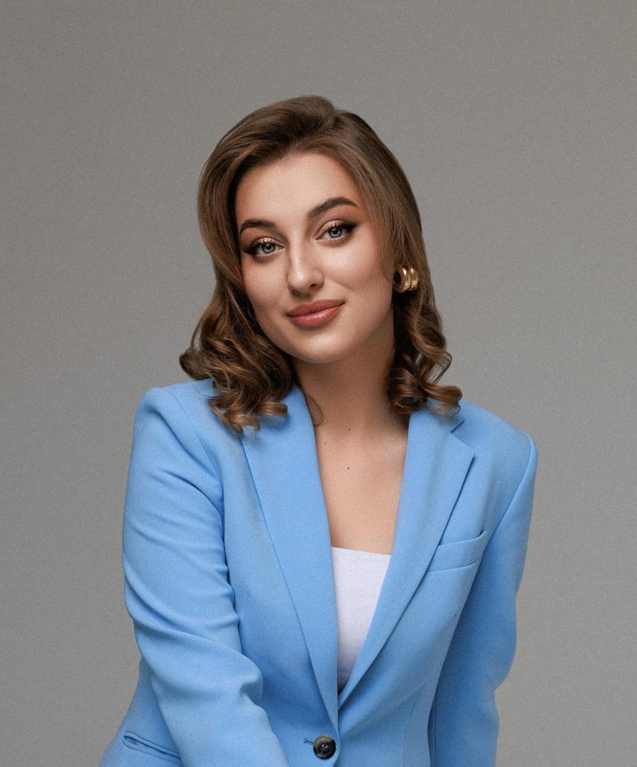 Portrait of Cristina Girnet smiling, wearing a sky-blue blazer